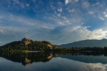 Bled castle at sunrise with mountain