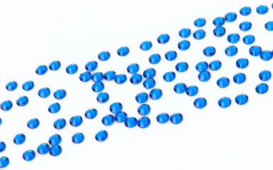 Precious sparkling rhinestones Capri blue colors on a white background.