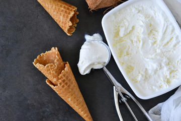 Coconut ice cream with waffle cone on black background