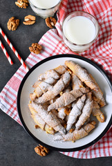 Homemade bagels with walnuts and milk on a black background