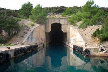 Concrete bunker shelter for submarines in adriatic sea. Beautifull clear blue water sea.