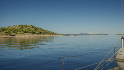 Sailing boat Moving In The Sea With Island in The Background