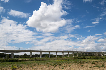 Paysage avec un pont et de baux nuages sur le ciel bleu.