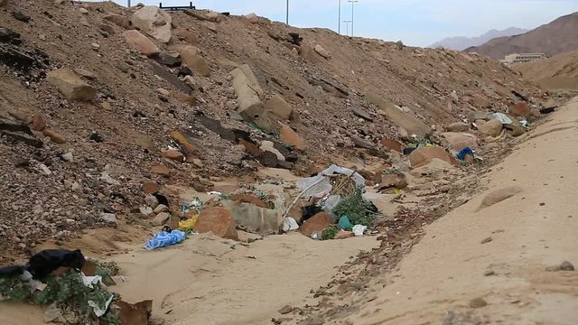 Garbage lies near narrow-gauge railway in Aqaba, Jordan. Trash lies near decauville. Rubbish near light railway