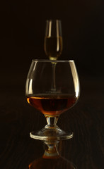 Glass with white, red wine and cognac or whisky on mirror table. Celebrities composition. selective focus