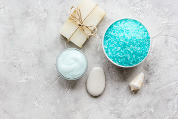 Home cosmetic with cream and blue sea salt on stone background top view mock-up