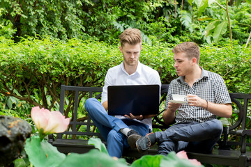Fototapeta premium Two business people use of the notebook computer at outdoor