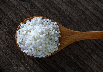 rice in spoon on wooden
