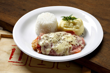 The steak parmigiana with potato and rice