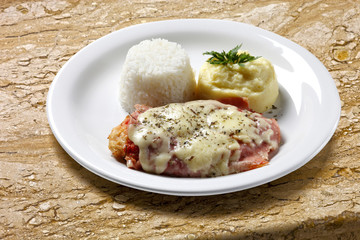 The steak parmigiana with potato and rice