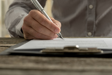 Closeup of male hand signing business contract or document