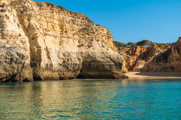 Fototapeta na wymiar Scenic golden cliffs near Alvor, Portimao. This beach is a part of famous tourist region Algarve