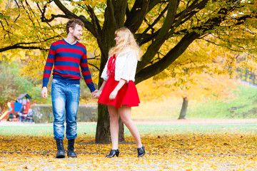 Naklejka premium Young couple meet in park on date holding hands.