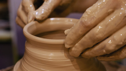 Potter is making clay pot bowl or vase ceramics porcelain on the potter's wheel. Creating pottery art and handicraft modelling creation.