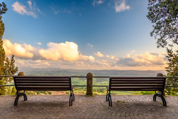 Benches along a sidewalk outside the famous town of Volterra
