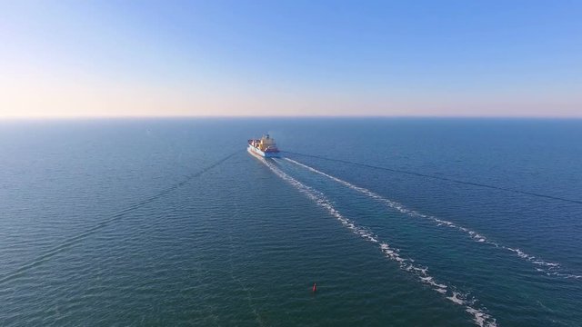 Aerial view of container ship floats in the open ocean after loading in the port of China at full speed. 4K.