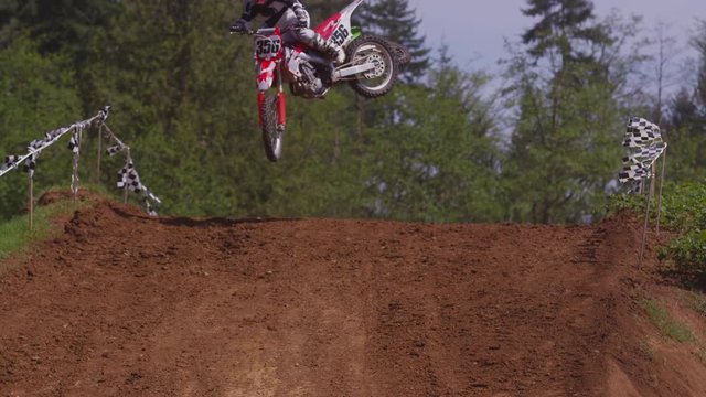 Motocross racers going over big jump in slow motion 