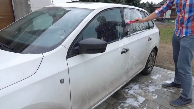Man washing car, brushing windshield in garden, super slow motion 240fps
