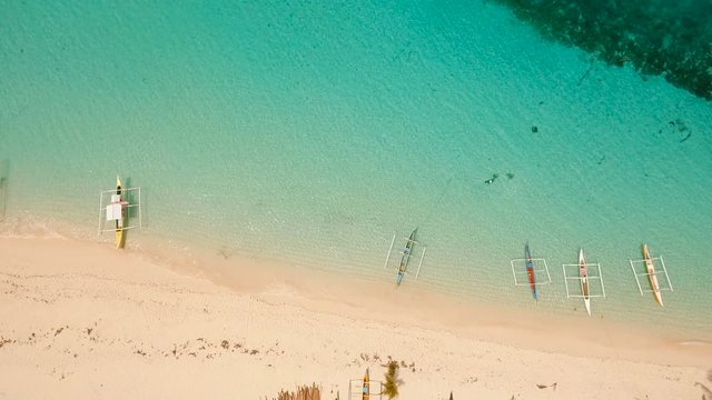 Aerial view of beautiful tropical island Daco with white sand beach. View of a nice tropical beach from the air. Beautiful sea, resort. Seascape: Ocean and beautiful beach paradise. Philippines. 4K