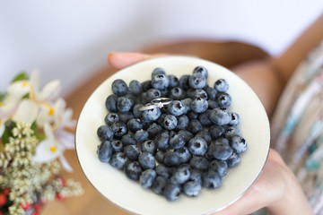 Blueberry and silver earring, ring on the white plate. Berrie at the wooden table. Fruit. Wedding, bride jewelry