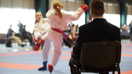 Martial art competitions - coach-judge at karate teenager's fighting