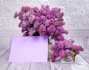 purple lilac bouquets on a gray background with a paper to sign