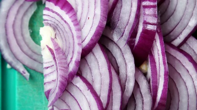 Close up of sliced red and white onion on cutting board. Food background. Dolly slider shot 4K ProRes HQ codec