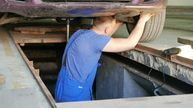 
4K.Mechanic repair  car, checks a wheel
