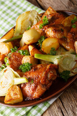 Pieces of chicken baked with fennel and potatoes close-up. vertical