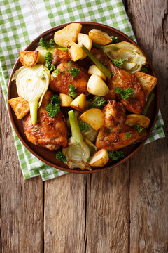 Moroccan food: pieces of chicken baked with fennel and potatoes close-up. Vertical top view