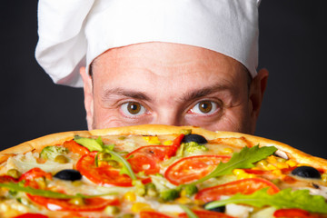 Portrait of happy attractive cook with a pizza