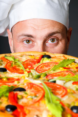 Portrait of happy attractive cook with a pizza