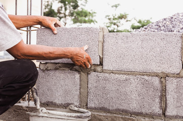 bricklayer installing bricks Masonry work in construction site
