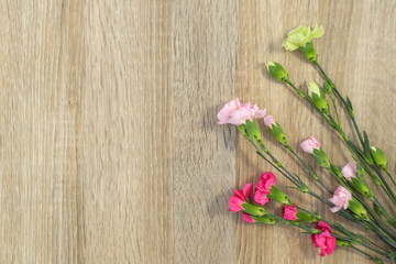 Flowers lie on a wooden surface and place for text.