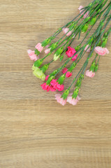 Flowers lie on a wooden surface and place for text.