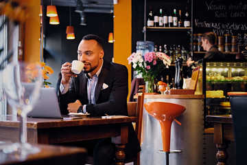 A man drinks coffee in a restaurant.