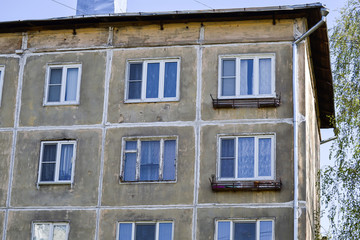 A multi-storey residential building of the Soviet period. Gray faceless windows and walls. Russia.