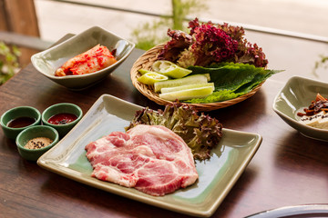 pork stake, pieces of crude meat prepared for preparation with greens