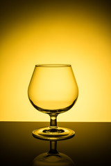 Empty wine glass on yellow background