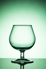 Empty wine glass on a green  background