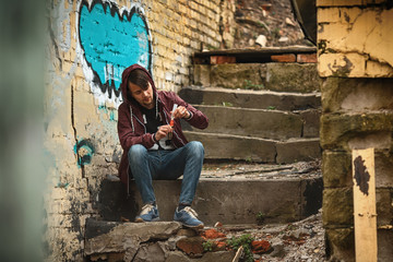 Vape man. Photo of a handsome young white guy in the hood vaping an electronic cigarette on an old...