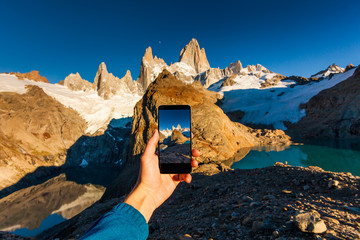 Taking a photo of mountains on a smartphone. Patagonia