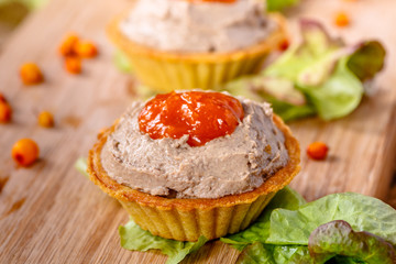 Tartlets with liver pate from duck or chicken livers and a sauce of sea-buckthorn are on the Board.