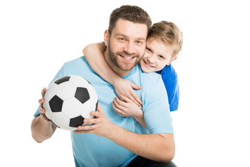 Young father and son posing with soccer ball isolated on white