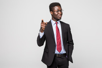 Handsome young African man in formalwear pointing on you while standing against grey background