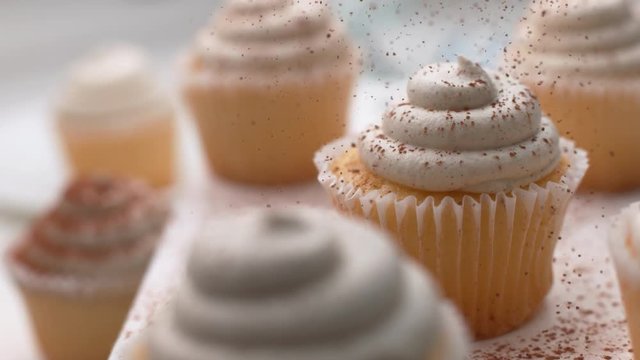 Cinnamon sprinkled onto vanilla cupcakes in super slow motion, shot on Phantom Flex 