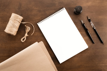 Top view of fountain pen, drawing album and water brush pen on wooden table