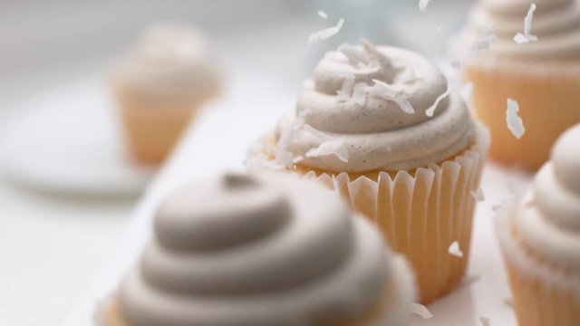 Coconut flakes falling onto cupcakes in super slow motion, shot on Phantom Flex 
