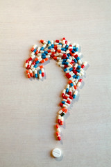 Pills and capsules forming a question mark