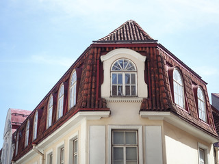 Yellow house with a red tiled roof and windows